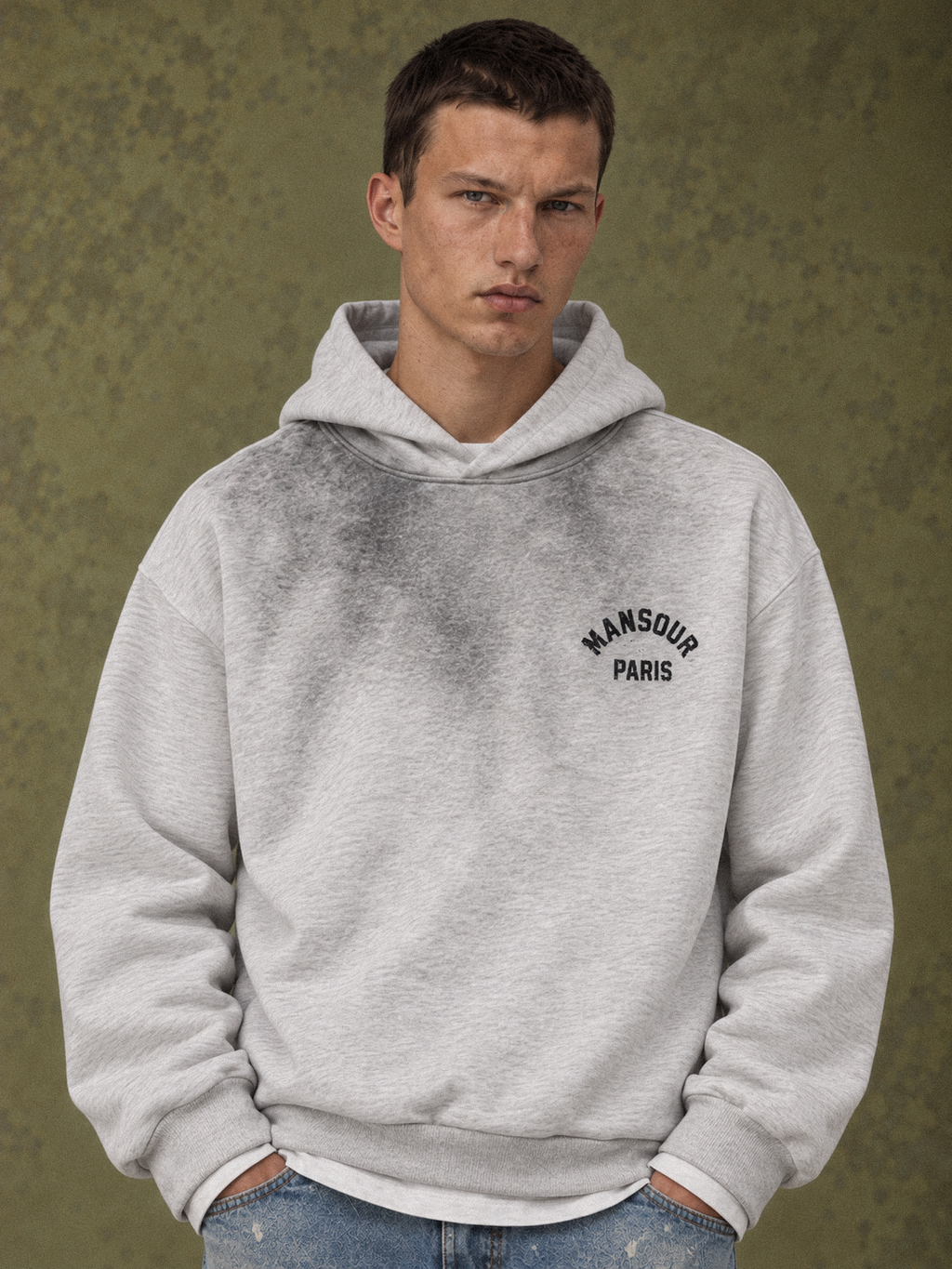 Sprayed Hoodie Athletic Heather d'Art. Department, porté par un mannequin, gros plan